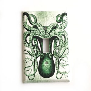 May include: A light switch cover with a green octopus illustration. The octopus has many tentacles and is surrounded by a white background.