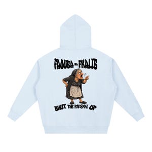 Puede incluir: Una sudadera con capucha azul claro que presenta un gráfico en la espalda de una persona mayor con un vestido oscuro estampado y un delantal, señalando y gritando. El texto superior dice FAOUZA NA FKALIS y el inferior SHUT THE F#@%! UP.