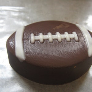 Una docena de galletas sándwich cubiertas de chocolate con forma de balón de fútbol como obsequios para fiestas.