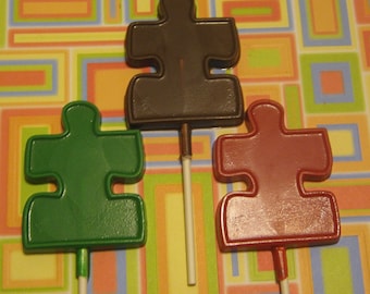 One dozen large puzzle piece lollipop suckers