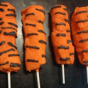 May include: Four orange and black tiger-striped marshmallow pops on sticks.