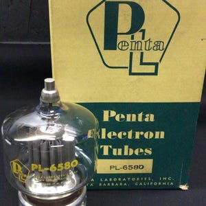 Op de afbeelding: Een doorzichtige glazen vacuümbuis met het label PL-6580 en een metalen voet, geplaatst voor een rechthoekige kartonnen doos. De doos is geel en groen met de tekst Penta Electron Tubes en Penta Laboratories, Inc. Santa Barbara, California.
