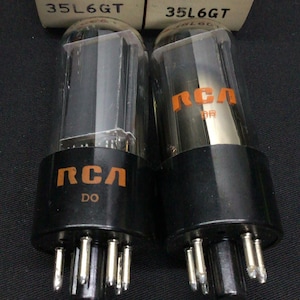 Może przedstawiać: Dwie lampy próżniowe RCA 35L6GT w stylu vintage z przezroczystymi szklanymi obudowami i czarnymi podstawami. Lampy mają logo RCA i numer modelu. Pudełka są białe z czerwonym brandingiem RCA i informacjami o modelu.