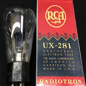 Puede incluir: Un tubo electrónico RCA Radiotron UX-281 de vidrio transparente con base negra y pines metálicos, junto a su caja de cartón original roja, negra y blanca. La caja muestra el logotipo de RCA, el texto UX-281 y Radiotron Electron Tube.