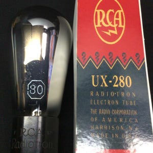 May include: A silver-toned RCA Radiotron UX-280 electron tube with a black base and a white number 80 printed on the glass. Beside it stands a rectangular box with a red top, a dark blue bottom, and the text RCA, UX-280, Radiotron Electron Tube.