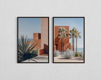 May include: Two framed photographs of a modern architectural building with palm trees and desert plants. The building is a light orange colour and the sky is blue.