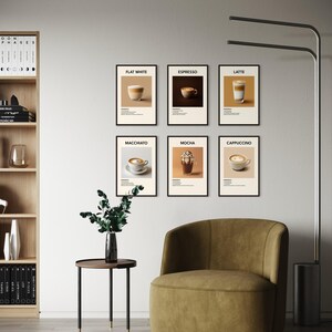 May include: Six black framed prints with white backgrounds and black text. Each print features a different type of coffee drink, including flat white, espresso, latte, macchiato, mocha, and cappuccino. The prints are displayed on a white wall above a brown armchair and a small round table with a green plant.