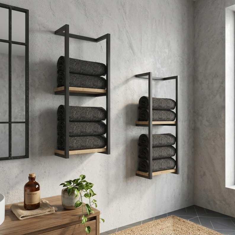 Black metal towel holder with wooden shelves and folded towels