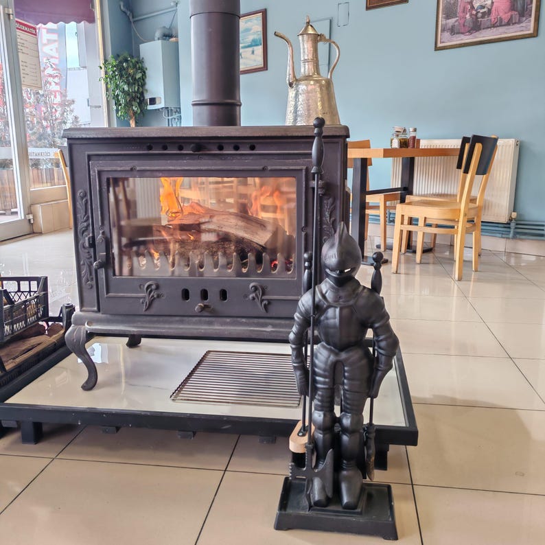 Unique knight-shaped stand holding a complete set of fireplace tools, perfect for enhancing a fireplace's medieval charm.