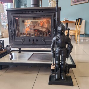 Unique knight-shaped stand holding a complete set of fireplace tools, perfect for enhancing a fireplace's medieval charm.
