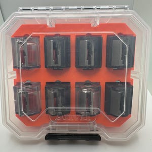 May include: A clear plastic storage case with an orange interior. The case contains eight small, clear plastic containers with black and silver components. The case has the word "Arvyl" printed on the front.