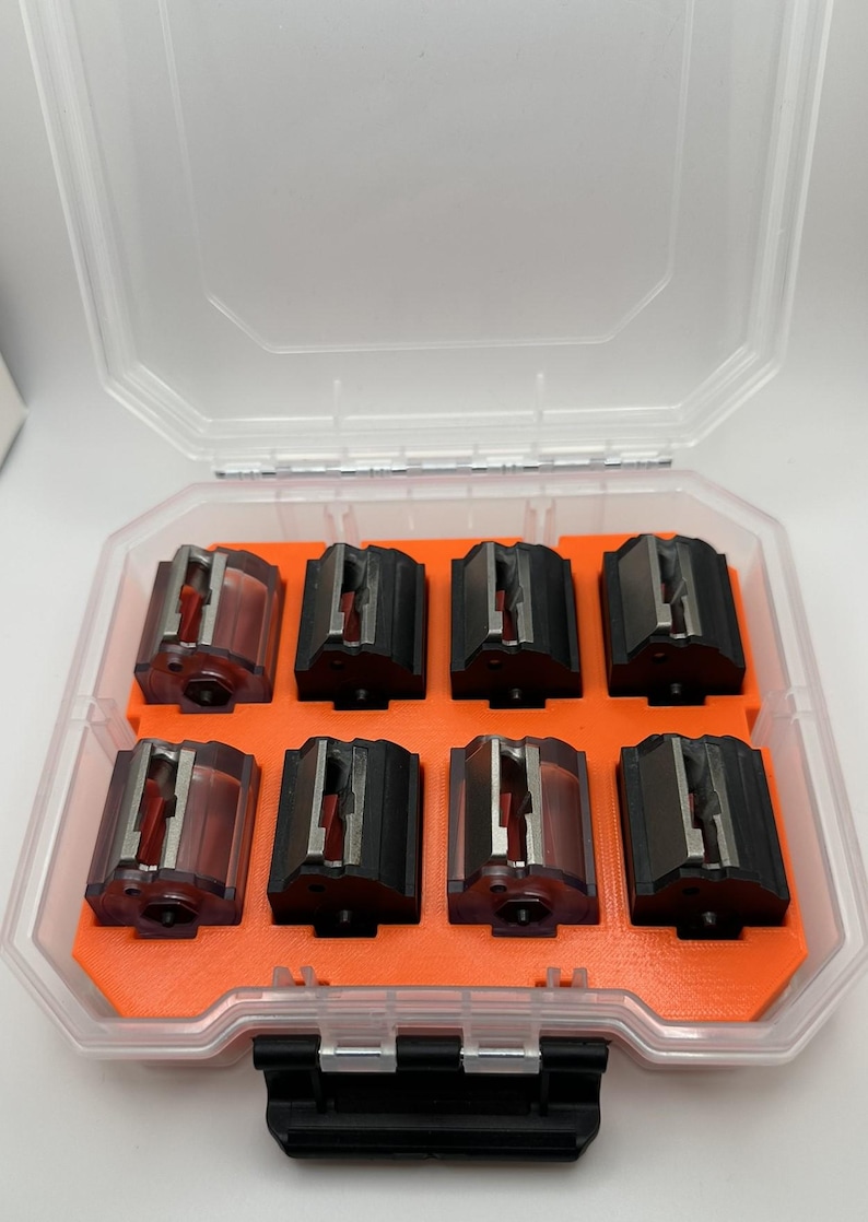 May include: A clear plastic storage case with an orange interior holds eight black and clear magazine inserts.