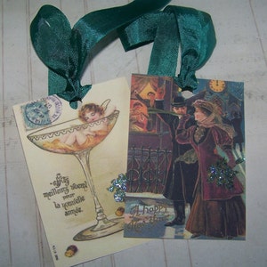 May include: Two vintage New Year's Eve greeting cards. The first card features a champagne glass with a cherub inside and the text "Mes meilleurs voeux pour la nouvelle ann&eacute;e." The second card features a couple in formal attire with the text "A Happy New Year".