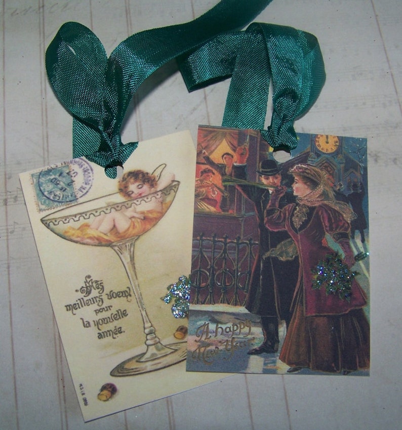 May include: Two vintage New Year's Eve greeting cards. The first card features a champagne glass with a cherub inside and the text "Mes meilleurs voeux pour la nouvelle ann&eacute;e." The second card features a couple in formal attire with the text "A Happy New Year".