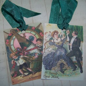 May include: Two vintage New Year's Eve gift tags with green ribbon. One tag features a champagne bottle with a clock face and the text "A Happy New Year". The other tag features a couple dancing with the text "A Happy New Year".