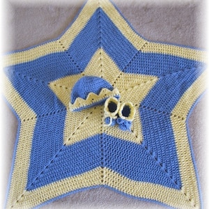 Peut inclure: Une couverture bébé en crochet en forme d'étoile bleue et jaune avec un bonnet et des chaussons assortis.
