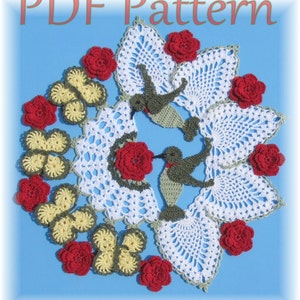 May include: White crochet doily featuring two green hummingbirds, red flowers, and yellow butterflies. The doily is set against a blue background. PDF Pattern.