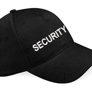 May include: Black baseball cap featuring the word "SECURITY" in white embroidery. The cap has a curved peak and a button at the crown. This hat is designed for security staff.