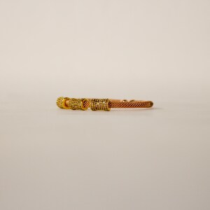 Unique golden mesh bracelet, adorned with vibrant crystals for a pop of color. The three meticulously crafted crystal-encrusted cylindrical accents create a perfect balance of elegance and modern style. Lightweight and comfortable for versatile use.
