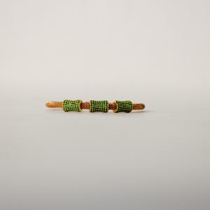 Unique golden mesh bracelet, adorned with vibrant crystals for a pop of color. The three meticulously crafted crystal-encrusted cylindrical accents create a perfect balance of elegance and modern style. Lightweight and comfortable for versatile use.
