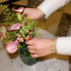 Unique golden mesh bracelet, adorned with vibrant crystals for a pop of color. The three meticulously crafted crystal-encrusted cylindrical accents create a perfect balance of elegance and modern style. Lightweight and comfortable for versatile use.