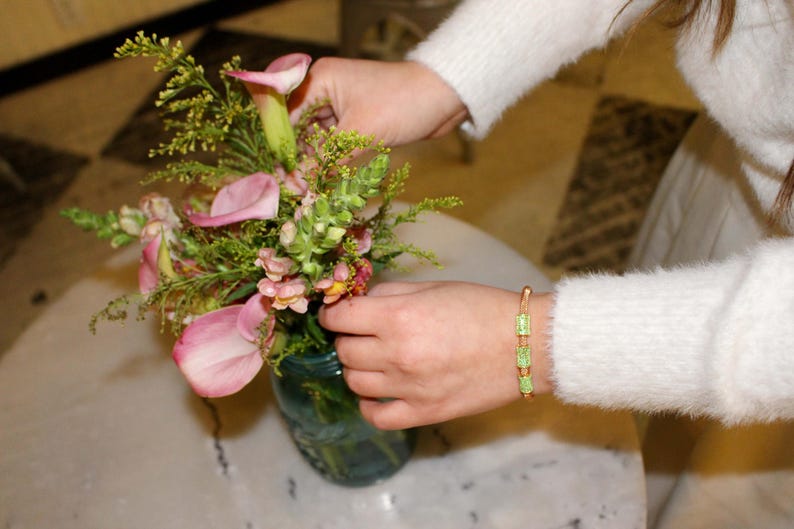 Unique golden mesh bracelet, adorned with vibrant crystals for a pop of color. The three meticulously crafted crystal-encrusted cylindrical accents create a perfect balance of elegance and modern style. Lightweight and comfortable for versatile use.
