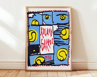 May include: A framed art print featuring a colorful design with tennis balls and the text "Roland Garros 1988." The artwork has a blue background with yellow tennis balls and red accents. The print is displayed on a wooden floor.