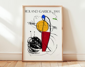 May include: Framed art print featuring the text "ROLAND GARROS 1991" above an abstract design. The artwork includes a yellow circle, red shape, black scribbles, and blue and green accents on a white background.