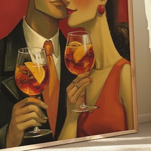 May include: A framed art print depicts a couple about to kiss, holding glasses of an orange cocktail with orange slices. The man wears a black suit and orange tie, while the woman wears a red dress and earrings. The background is red.