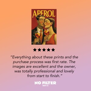 May include: Aperol art print featuring a couple toasting with Aperol spritzes. The artwork has a vintage style with a red and orange color scheme. The print includes the word "APEROL" at the top.