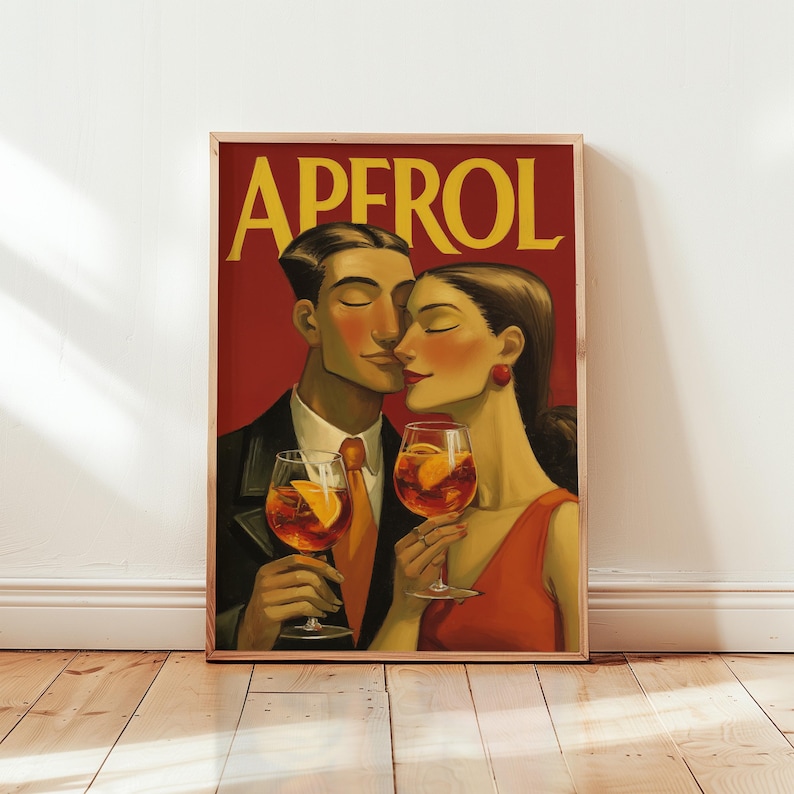 May include: A framed art print featuring a couple holding Aperol cocktails. The artwork has a vintage style with the word "APEROL" in yellow. The couple is depicted in a romantic embrace, with the woman in a red dress.