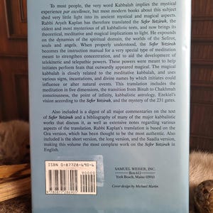 May include: A book titled "Sefer Yetzirah" by Rabbi Aryeh Kaplan, with text on the back cover. The cover is light blue with white text, including the ISBN and publisher information. The book explores Kabbalah's mystical and magical aspects.