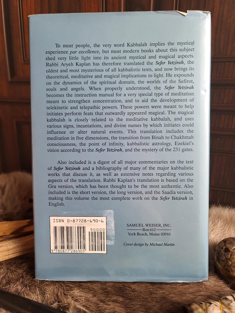 May include: A book titled "Sefer Yetzirah" by Rabbi Aryeh Kaplan, with text on the back cover. The cover is light blue with white text, including the ISBN and publisher information. The book explores Kabbalah's mystical and magical aspects.