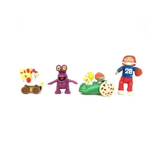May include: A set of four colourful toy figures. Includes a yellow and red wagon with a character, a purple alien-like figure, a green vehicle with two characters, and a football player figure.