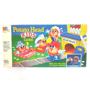 May include: A colorful board game box for the Potato Head Kids Game. The box features a cartoon image of a potato head with a red nose and a blue hat. The game is for ages 3-6 and is for 2 to 4 players. The box also features a cartoon image of a clubhouse.