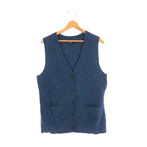 May include: A blue knit vest featuring a V-neckline, a front button closure with five dark buttons, and two front patch pockets. The garment is constructed with a textured, speckled knit pattern and is displayed on a wooden clothes hanger.