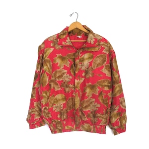 May include: A red and brown patterned jacket with a zipper closure and a drawstring waist.