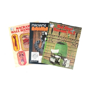 May include: Three vintage macrame books are shown on a white background. The titles read "Macrame Wall Hangings with Weaving", "Macrame Animals", and "Mad About Macrame, No. 2". The covers display illustrations of macrame projects.