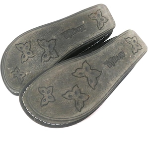 May include: A pair of dark gray Alegria brand shoe insoles. The insoles have a butterfly pattern and the brand name is printed on the side. The insoles are made of a durable material and are designed for comfort.
