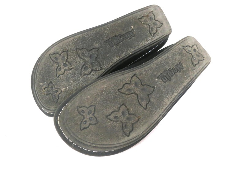May include: A pair of dark gray Alegria brand shoe insoles. The insoles have a butterfly pattern and the brand name is printed on the side. The insoles are made of a durable material and are designed for comfort.