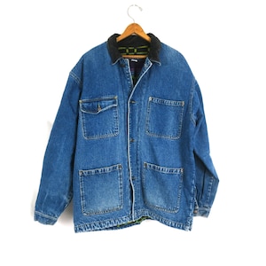 May include: A blue denim jacket with a black corduroy collar and four large front pockets. The jacket is button-down and has a quilted lining. The jacket is hanging on a wooden hanger.