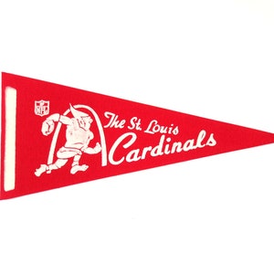 Könnte beinhalten: Rotes Wimpel mit weißem Text und Grafiken. Das Wimpel zeigt die Worte "The St. Louis Cardinals" und eine Cartoonfigur. Das NFL-Logo befindet sich in der oberen linken Ecke. Das Wimpel ist dreieckig.