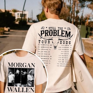 May include: Cream-colored t-shirt featuring a black and white image of Morgan Wallen and the text "MORGAN WALLEN". The back of the shirt displays "STILL THE PROBLEM TOUR 2026" with a bull skull graphic and a list of tour dates.