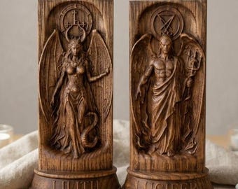 Peut inclure: Deux plaques rectangulaires de couleur bois brun avec des sculptures en relief. La plaque de gauche représente une figure ailée avec des cornes et une queue, marquée LILITH. La plaque de droite montre une figure ailée tenant un trident, marquée LUCIFER.