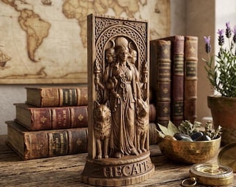 May include: A rectangular wooden carving of the goddess Hecate featuring three faces, holding torches, and flanked by two dogs. The base is inscribed with the text HECATE. The sculpture is rendered in a medium brown wood tone with intricate relief details.