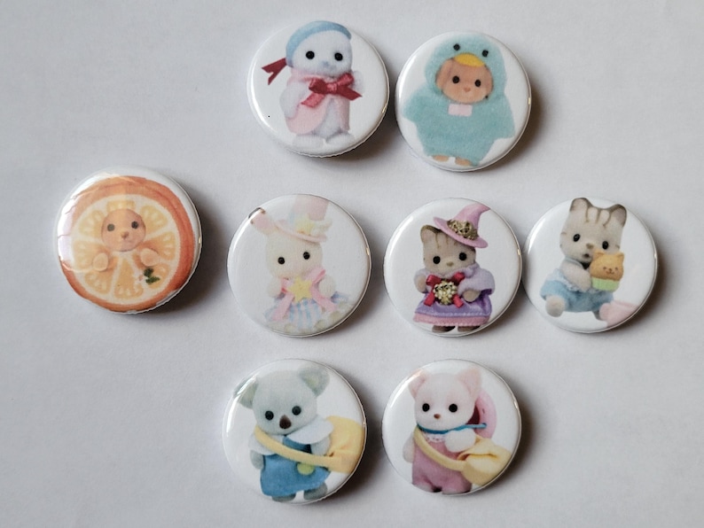 May include: A collection of eight round pinback buttons featuring various adorable animal characters in costumes. The buttons showcase a variety of colors, including pastels and bright hues, with detailed illustrations of each character.