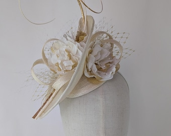An ivory fascinator with gold accents. Mounted on a fine wrapped headband. One size fits all