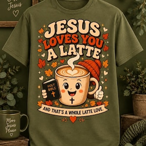 Puede incluir: Una camiseta verde oliva con el gráfico de una taza de café sonriente que lleva un gorro, sostiene una Biblia y hace un gesto de pulgar hacia arriba. El texto dice Jesus Loves You A Latte y And That's A Whole Latte Love, rodeado de hojas.