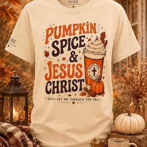 May include: A cream-colored short-sleeve t-shirt featuring the text PUMPKIN SPICE & JESUS CHRIST and BOTH GET ME THROUGH THE FALL. The graphic includes a coffee cup with a cross emblem, a pumpkin, and autumn leaves in orange and brown tones.