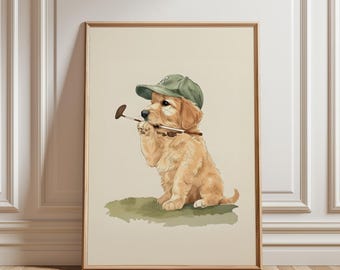 Könnte beinhalten: Gerahmter Druck mit einem Golden Retriever-Welpen, der eine grüne Kappe trägt und einen Poloschläger hält. Der Welpe sitzt auf einem Flecken grünen Grases. Das Kunstwerk hat einen hellbeige Hintergrund und einen Holzrahmen.
